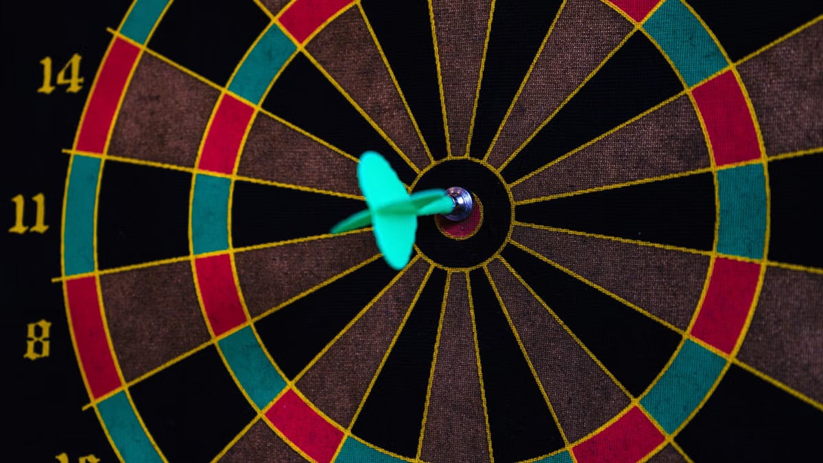 A vibrant close-up of a dart hitting the bullseye on a colorful dartboard, showcasing precision.